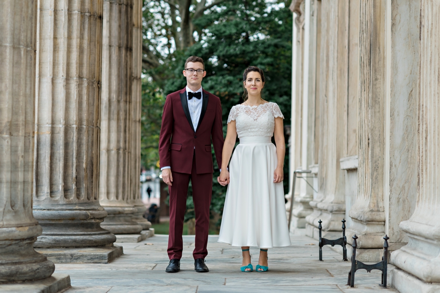 A wedding couple hold hands and smile in Philadelphia.